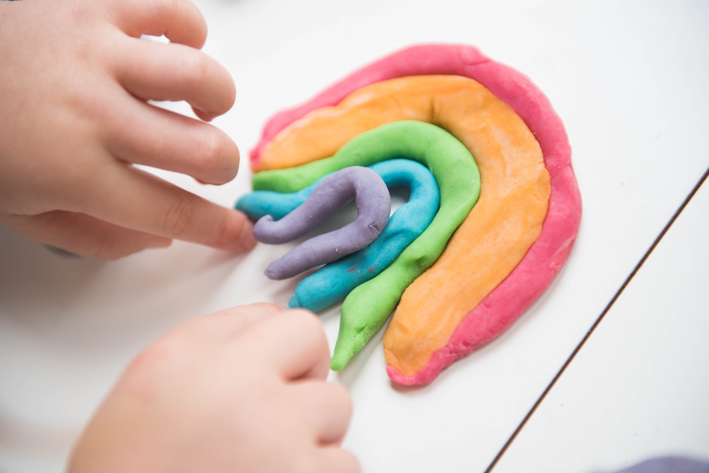Child shaping colourful playdough during a creative activity