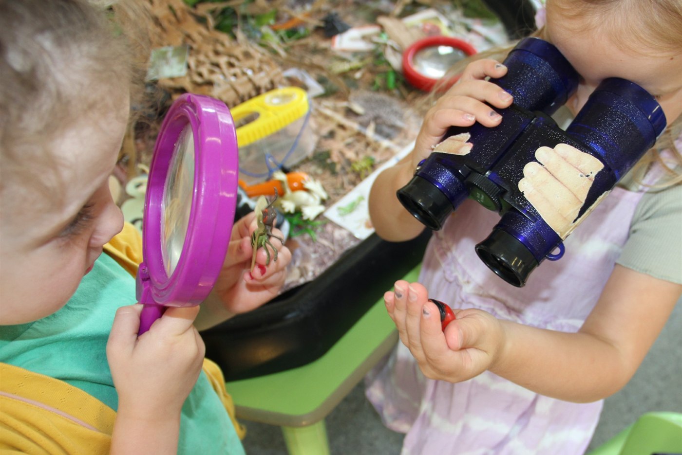 Children exploring nature with magnifying glasses and binoculars